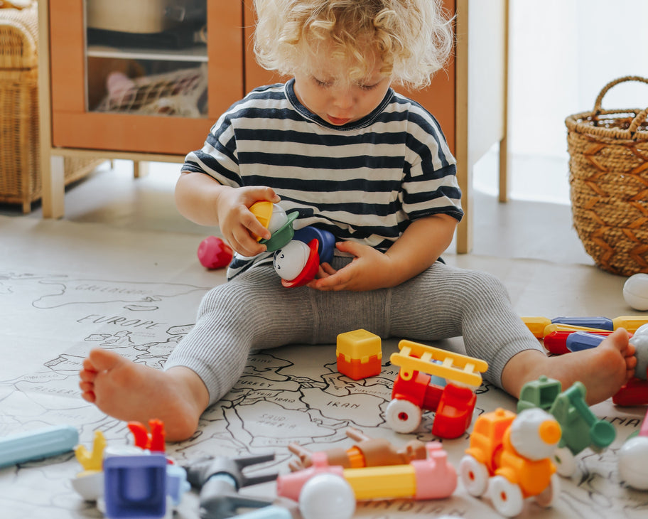 Peuter van 1 jaar speelt met houten stapeltoren, geschikt speelgoed vanaf 1 jaar