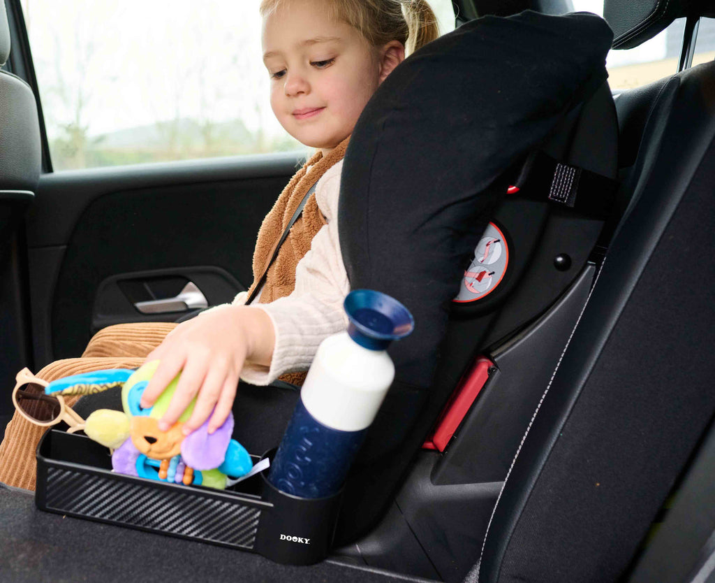 Dooky Seat Storage Buddy biedt plek voor drinkbeker, knuffel en kleurpotloden, bij De Gele Flamingo.