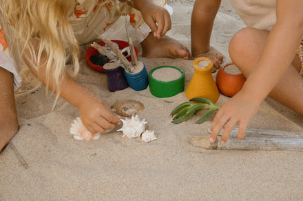 Kind speelt met Grapat Pots houten potjes om te vullen en legen