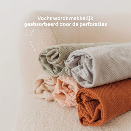 Opgerolde Aerosleep hoeslakens in verschillende kleuren, vocht wordt geabsorbeerd door de perforaties