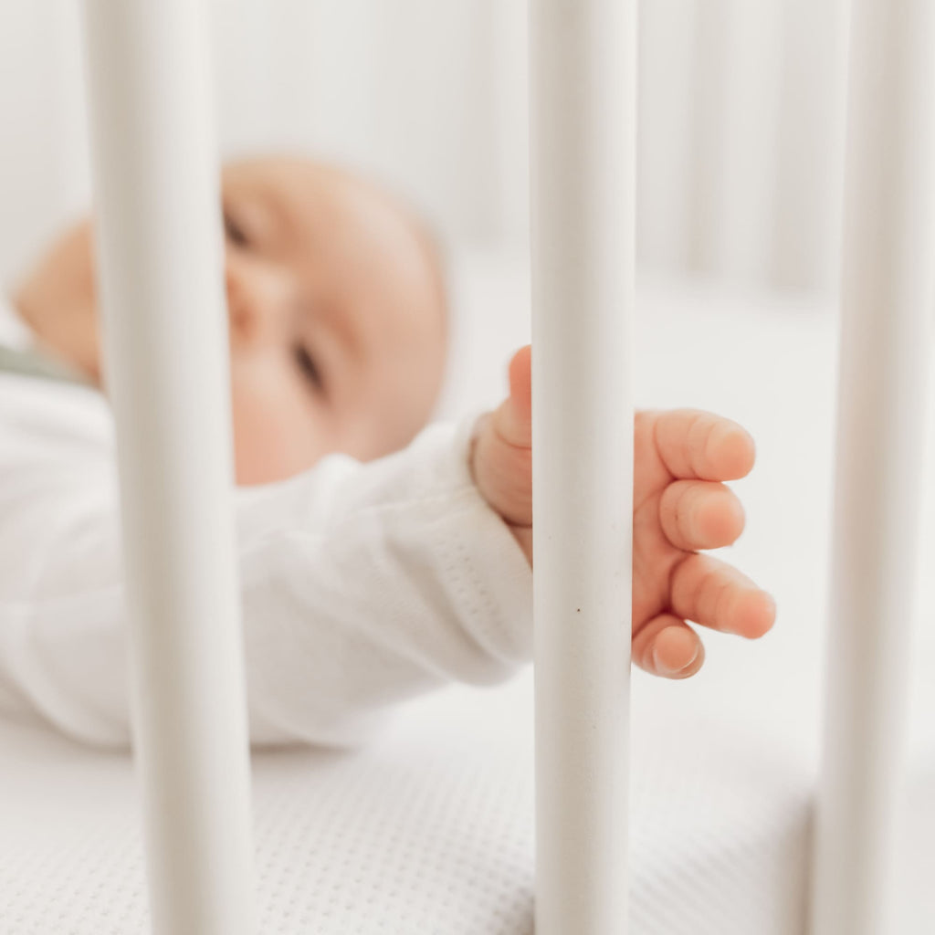 Baby in bed op Aerosleep hoeslaken wit