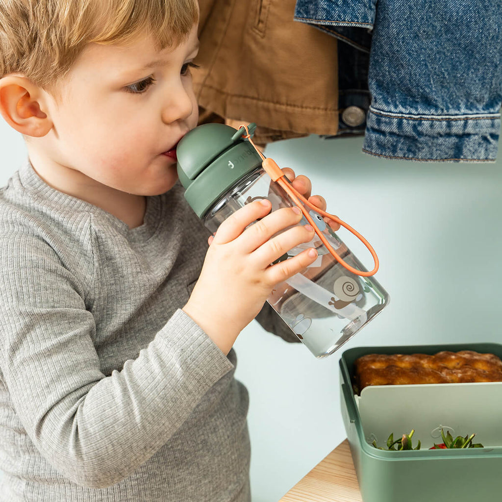Kindje drinkt uit de Done By Deer drinkfles Tiny Trails Green