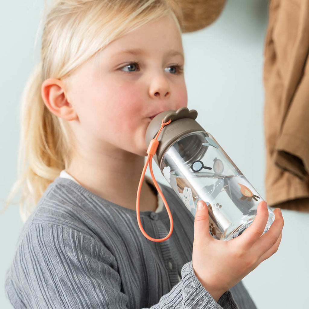 Kindje drinkt uit de Done By Deer drinkfles Tiny Trails Sand