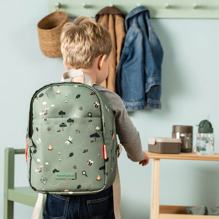 Kind draagt de groene Done By Deer Tiny Trails rugzak buiten