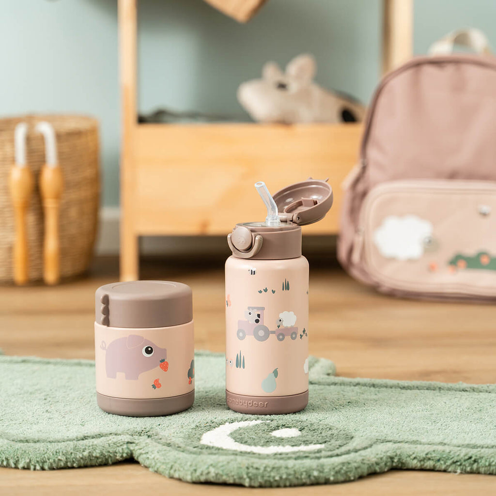 Kindje drinkt uit de Done By Deer thermosfles Tiny Farm Powder