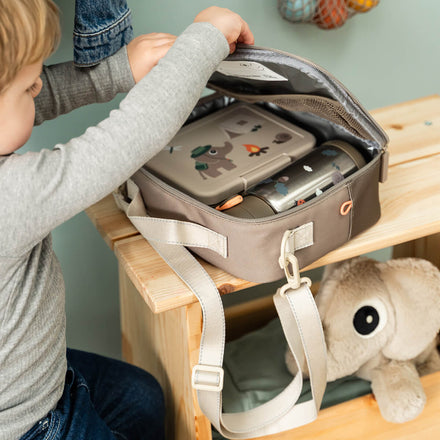Kind met de Done By Deer thermische lunchtas Tiny Trails Sand
