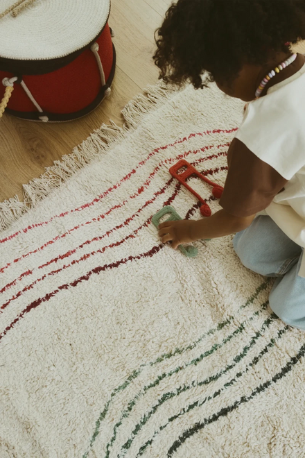 Pompons en franje aan de rand van het speelkleed