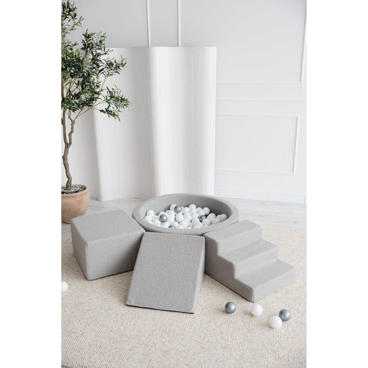 Moje rond ballenbad en playset bouclé grijs met trap en glijhelling in een lichte kamer