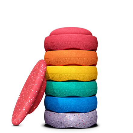 Stapelstein Winter Special Rainbow Set Classic, zes regenboogstenen gestapeld naast het rode board