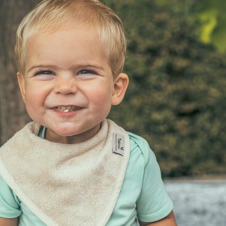 Baby draagt de Timboo waterproof bandana slab Frosted Almond van bamboebadstof