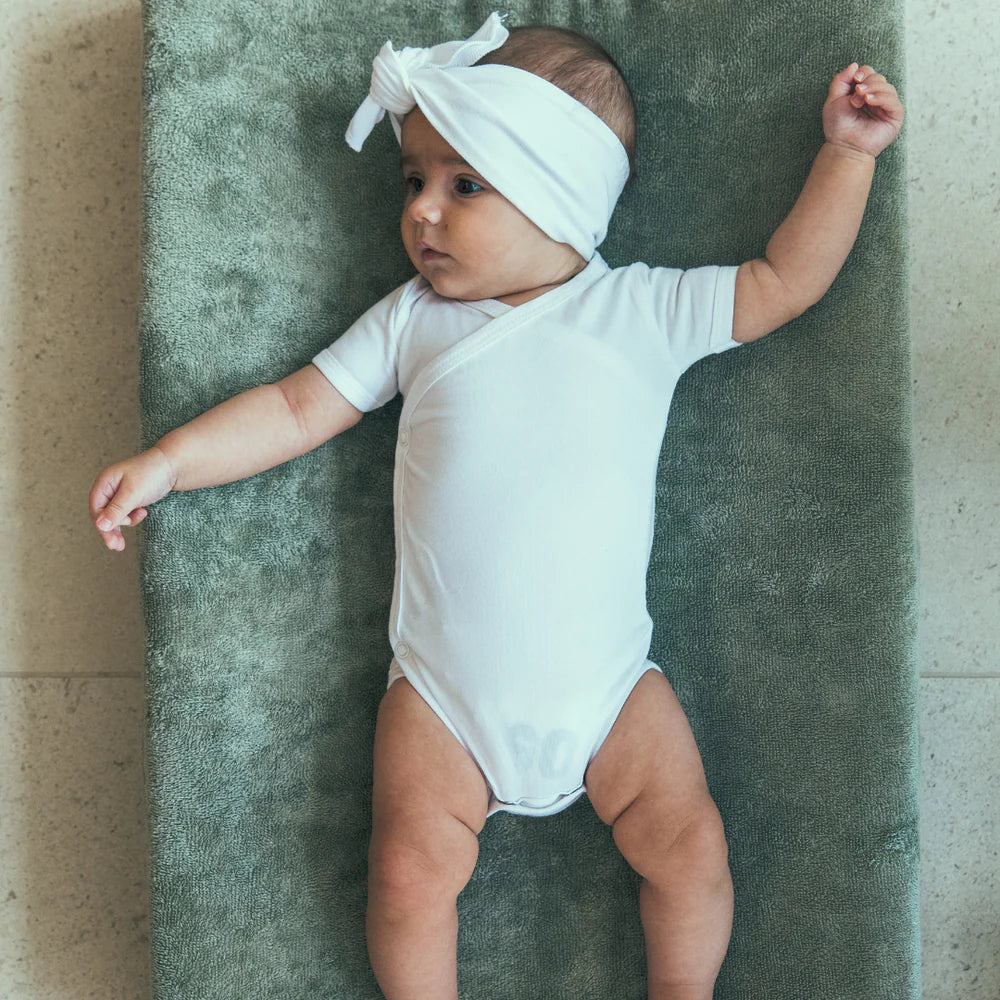 Timboo waskussenhoes Marin, sfeerbeeld: baby op een groene waskussenhoes