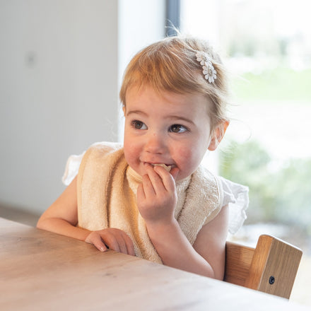 Timboo waterproof slab Frosted Almond, gedragen door een peuter aan tafel