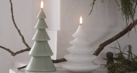 Uyuni LED kaars kerstboom Nordic White naast een Sage Green kerstboom met dennentakken