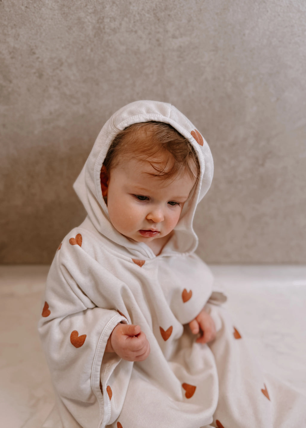 Poncho Tiny Hearts van Mrs. Ertha bij De Gele Flamingo, met drukknopen aan de zijkanten voor extra warmte