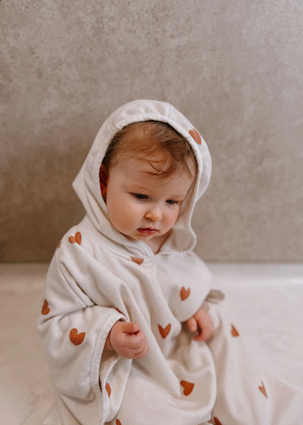 Poncho Tiny Hearts van Mrs. Ertha bij De Gele Flamingo, met drukknopen aan de zijkanten voor extra warmte