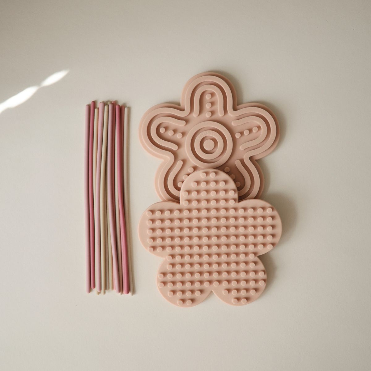 Mushie siliconen sensorisch speelgoed in pastel, dubbelzijdig speelbord bij De Gele Flamingo