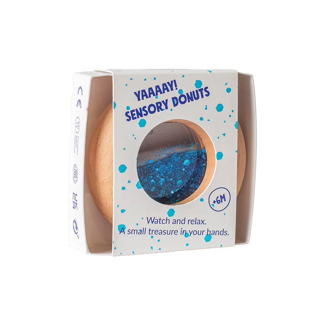Petit Boum Sensorische Donut blauw, transparante donut gevuld met glitters, gevonden bij De Gele Flamingo.