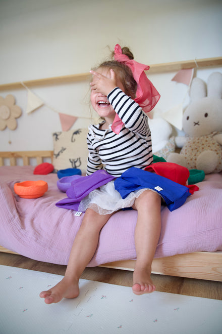 Pit & Play katoenen speeldoeken regenboog, meisje met doeken op bed
