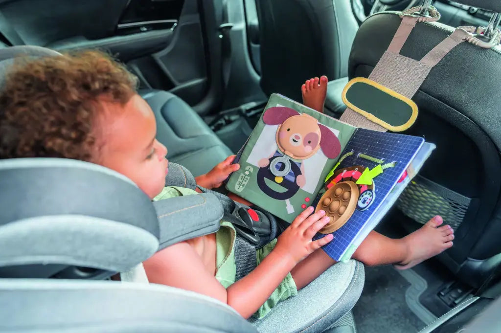Taf Toys Ride Time Busy Book aan de hoofdsteun van de autostoel, verkrijgbaar bij De Gele Flamingo.