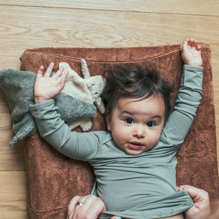 Timboo waskussenhoes Savannah Sand, met een lachende baby erop